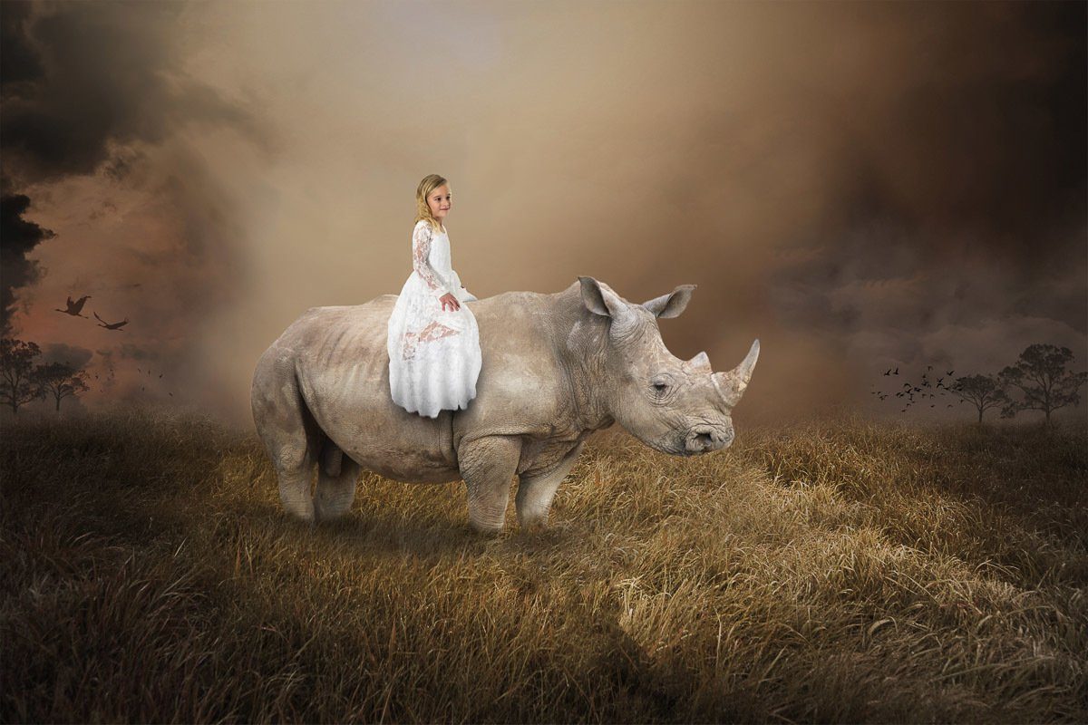 Papermoon Fotobehang Surreales Mädchen, das Nashorn reitet